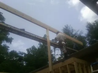 Carpenter setting a ridge beam over a new addition frame — Ice Dam Removal by Roofing Brothers in East Walpole