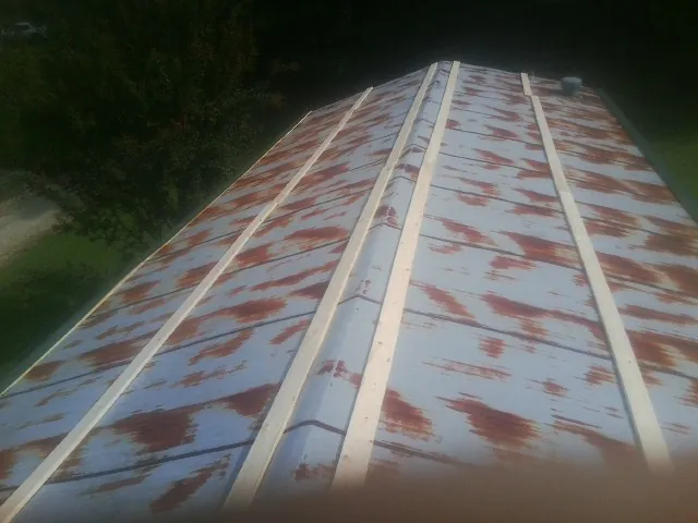 Rusted metal roof panels with new wood purlins before replacement — Storm Damage Roof Repair in East Walpole by Roofing Brothers